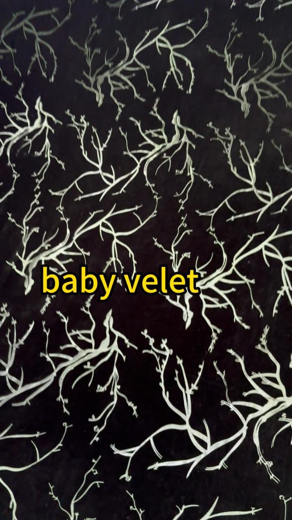 Dark green printed baby velvet fabric with a light green botanical branch pattern