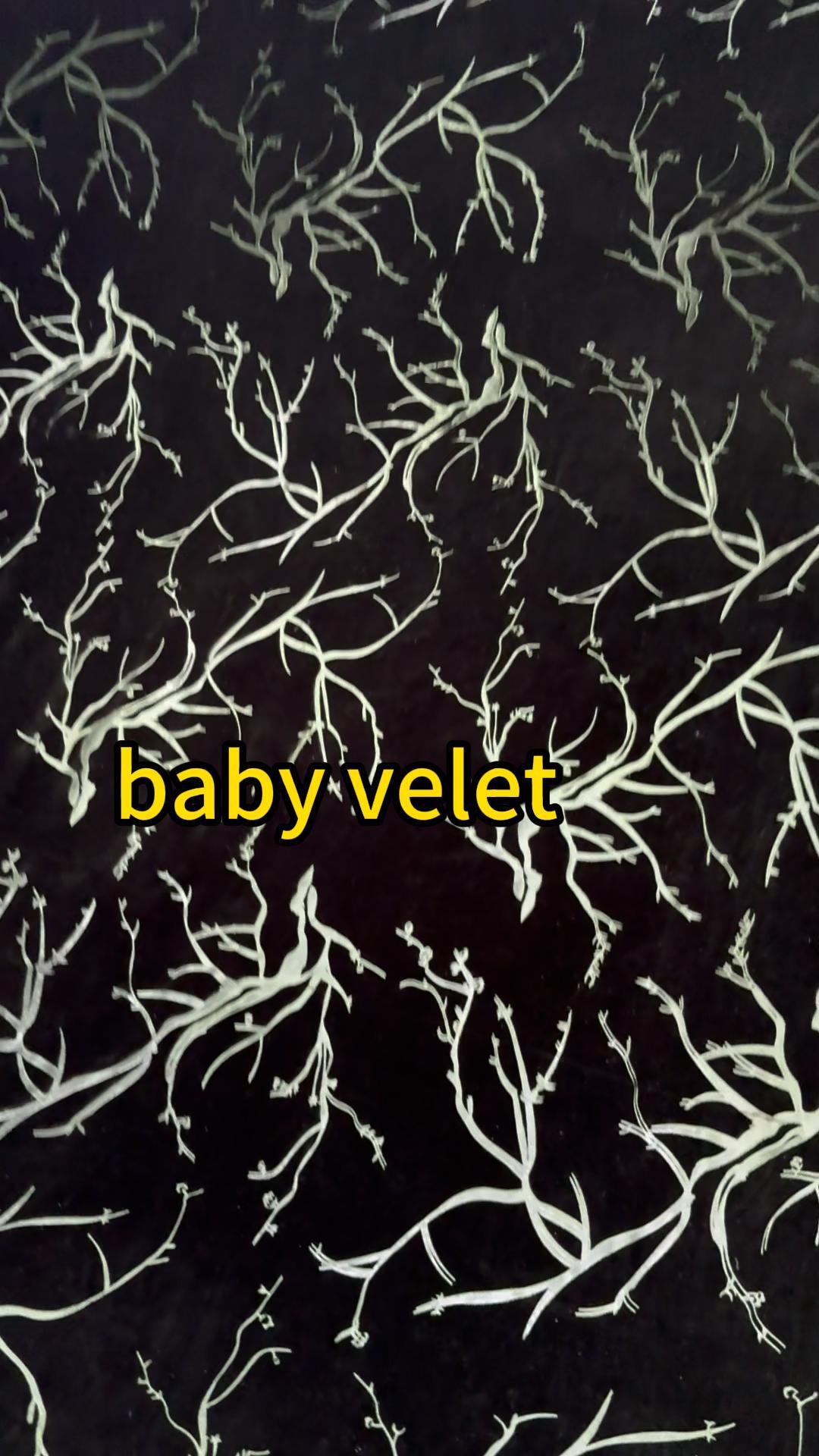 Printed Baby Velvet Fabric with Botanical Pattern Dark green printed baby velvet fabric with a light green botanical branch pattern